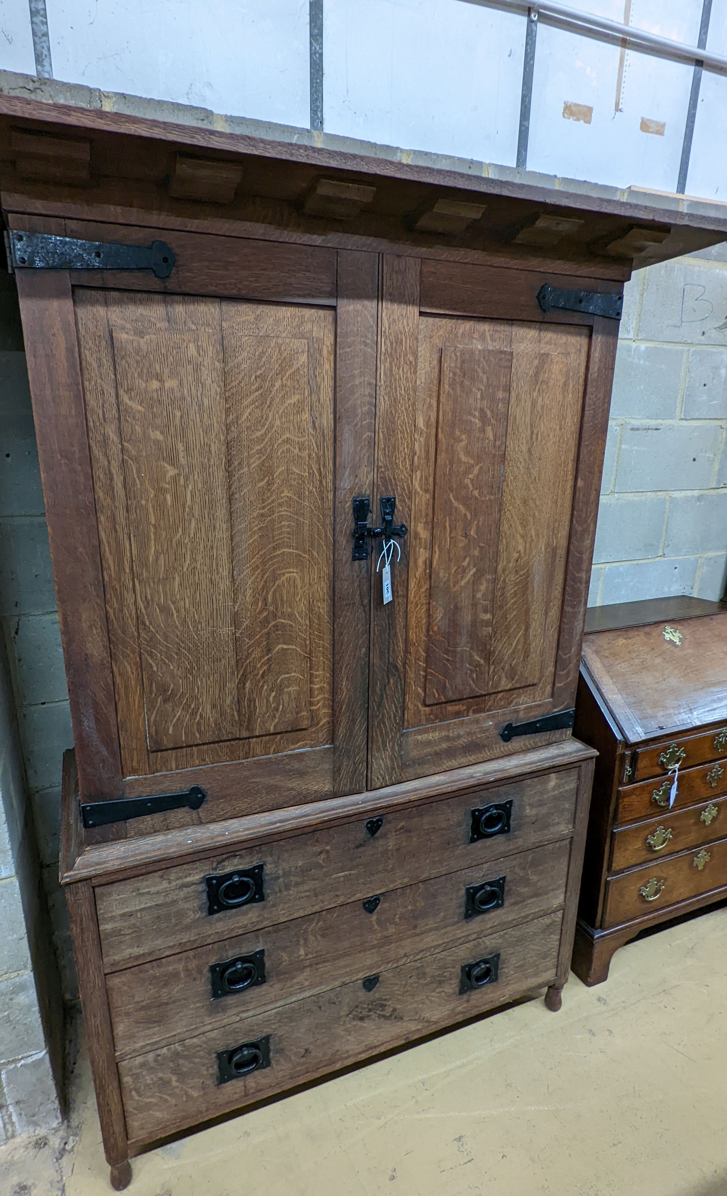 An early 20th century Arts & Crafts iron mounted oak linen press, width 140cm, depth 60cm, height 191cm